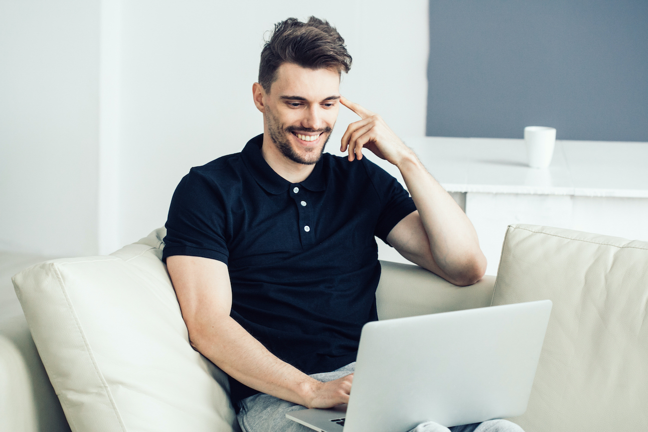 Handsome man with laptop home. Male portrait freelancer working home with computer online surfing internet
